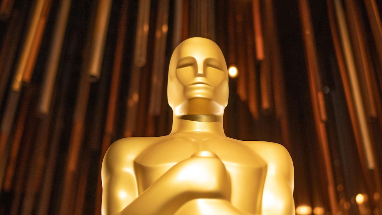 Une statue des Oscars devant un fond doré.