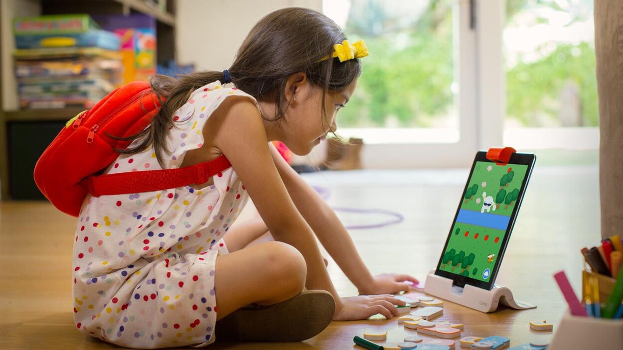 Une fillette apprend les rudiments du codage grâce à un jeu Osmo. Une fillette apprend les rudiments du codage grâce à un jeu Osmo.