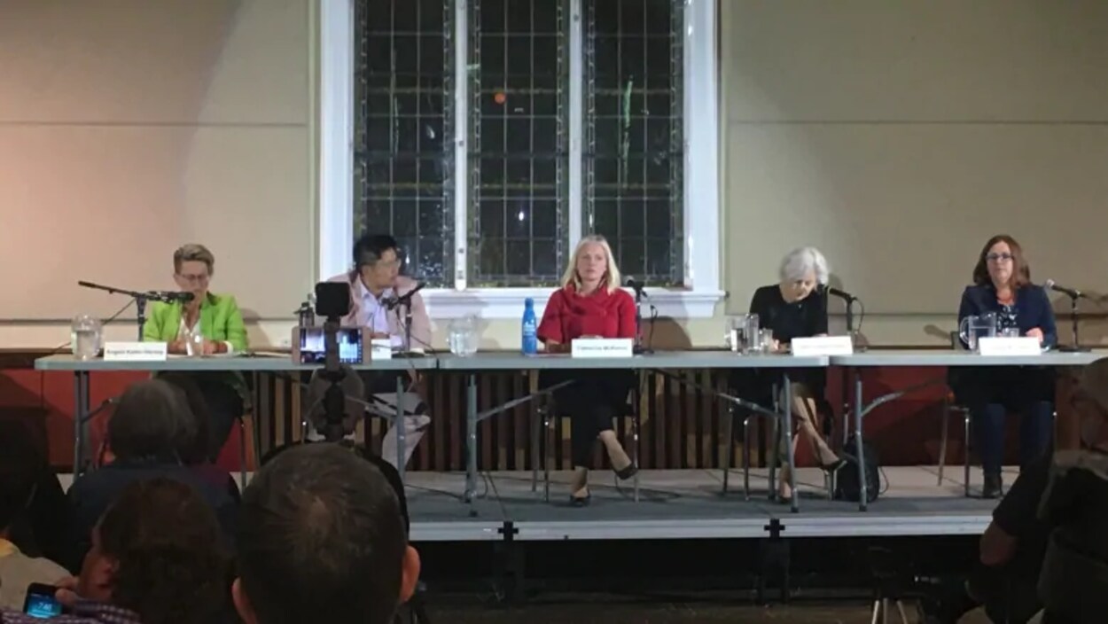 Cinq femmes derrière une table.