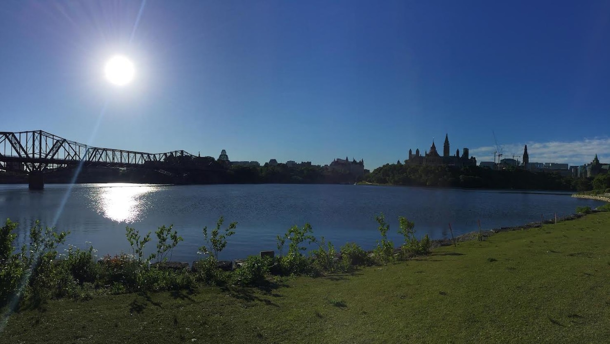 Un soleil se lève au-dessus du pont Alexandra et de la colline du parlement à Ottawa.