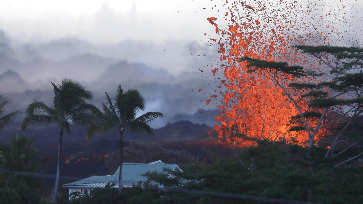 De la lave surgit d'une fissure du volcan Kilauea près d'une habitation à Hawaï.