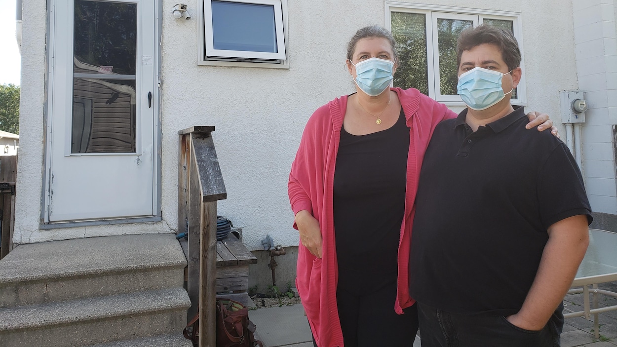 Anne-Claire et Nicolas Joffroy, portant le masque, devant la maison qu'ils habitent temporairement.