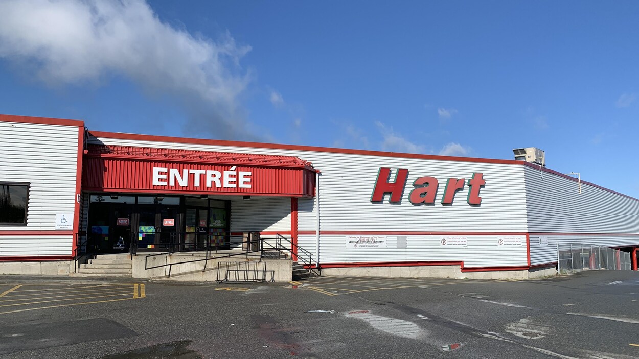 L'entrée d'un centre commercial. Des affiches « Entrée » et « Sortie » indiquent aux clients quelles portes ils doivent utiliser.