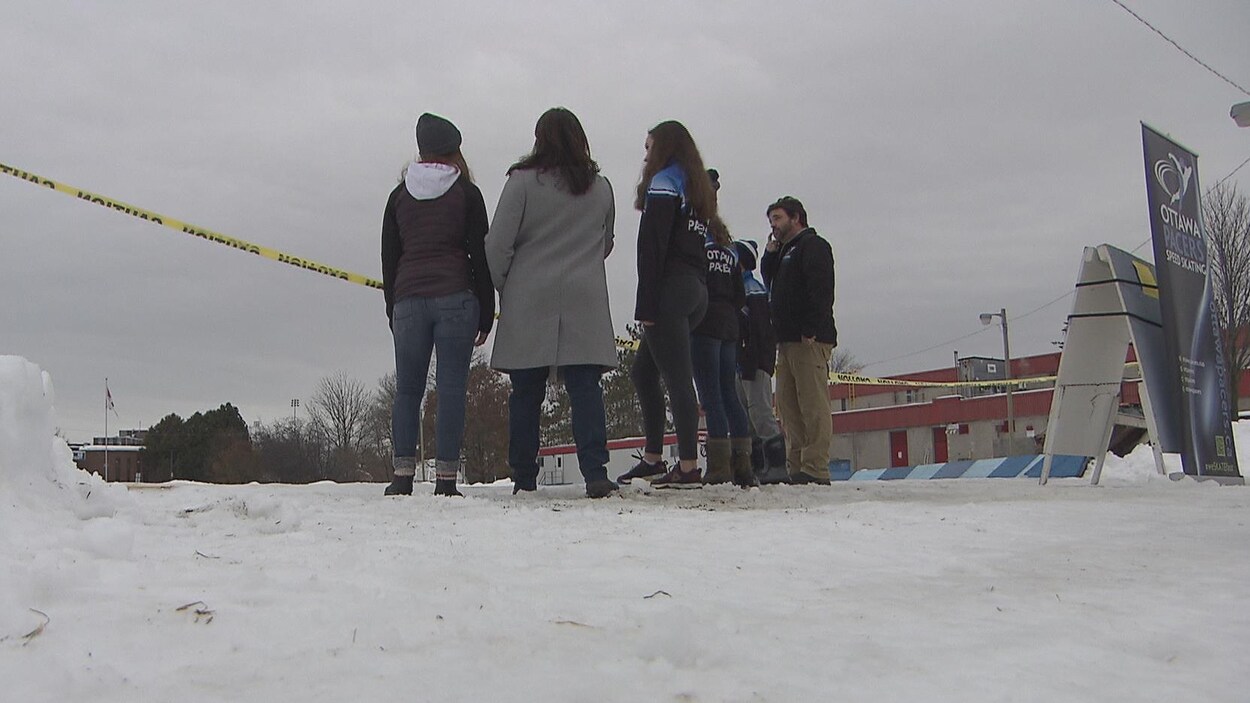Six personnes près d'une patinoire extérieure Six personnes près d'une patinoire extérieure