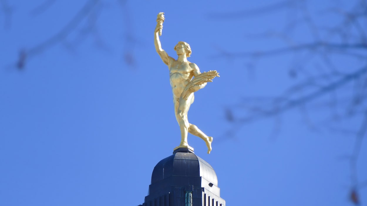 La statue Golden Boy surplombe le palais législatif du Manitoba sous un ciel dégagé.