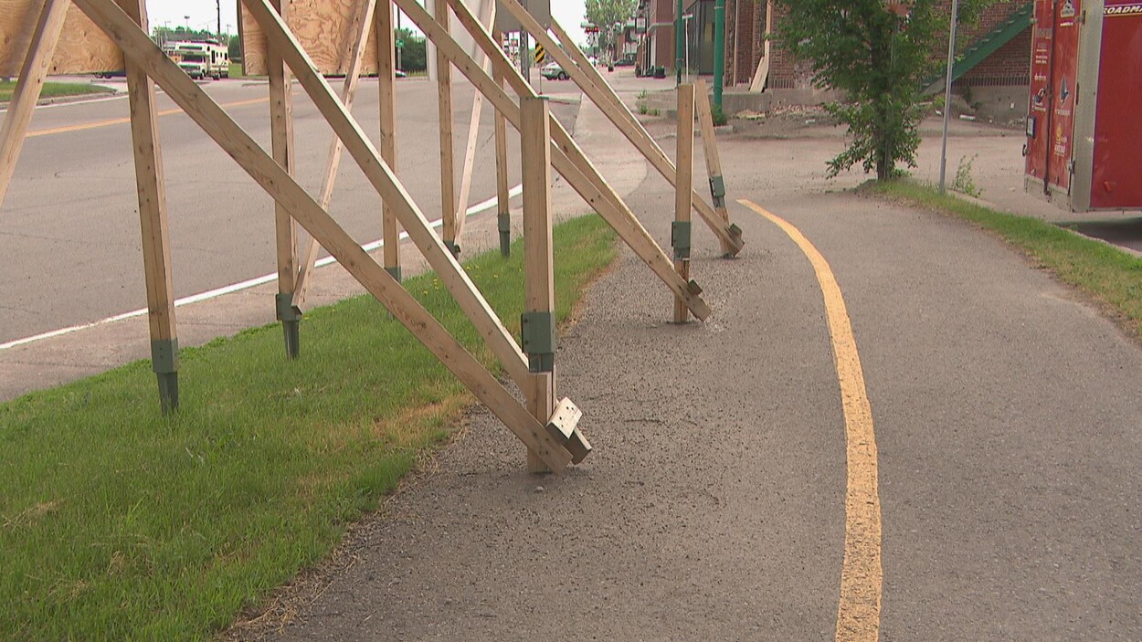 Des pancartes boulonnées dans la piste cyclable.
