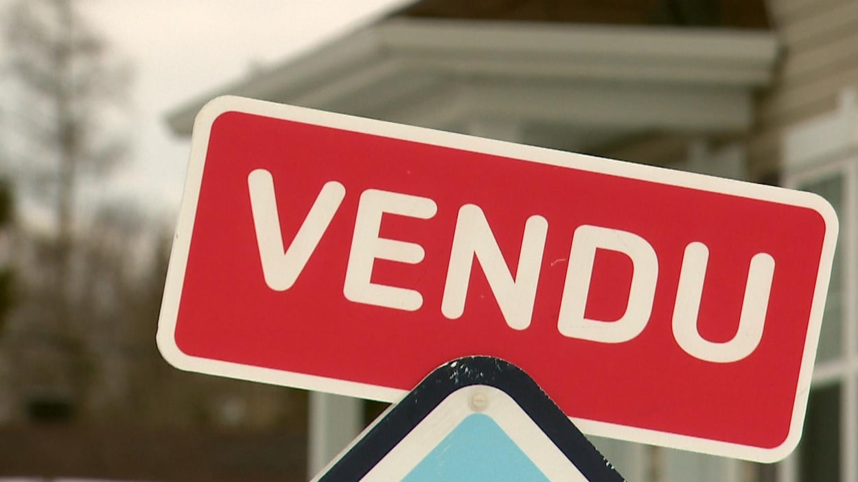 Une affiche d'agent immobilier qui indique la vente d'une maison à Québec.