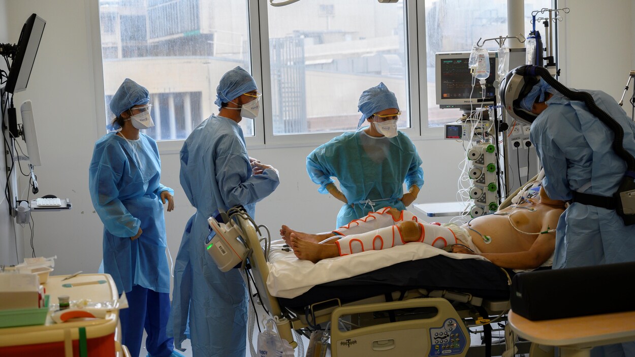 Du personnel soignant lors d'une intervention sur un malade en soins intensifs.