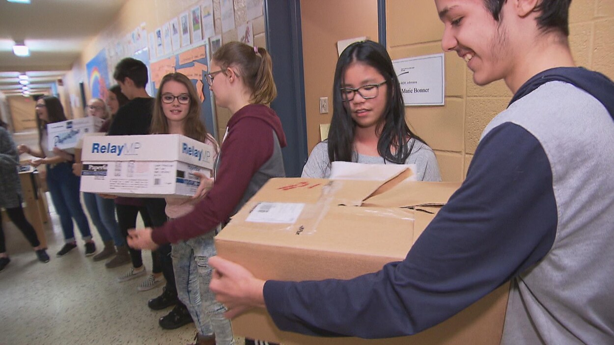 Jeunes qui transportent des boîtes Jeunes qui transportent des boîtes