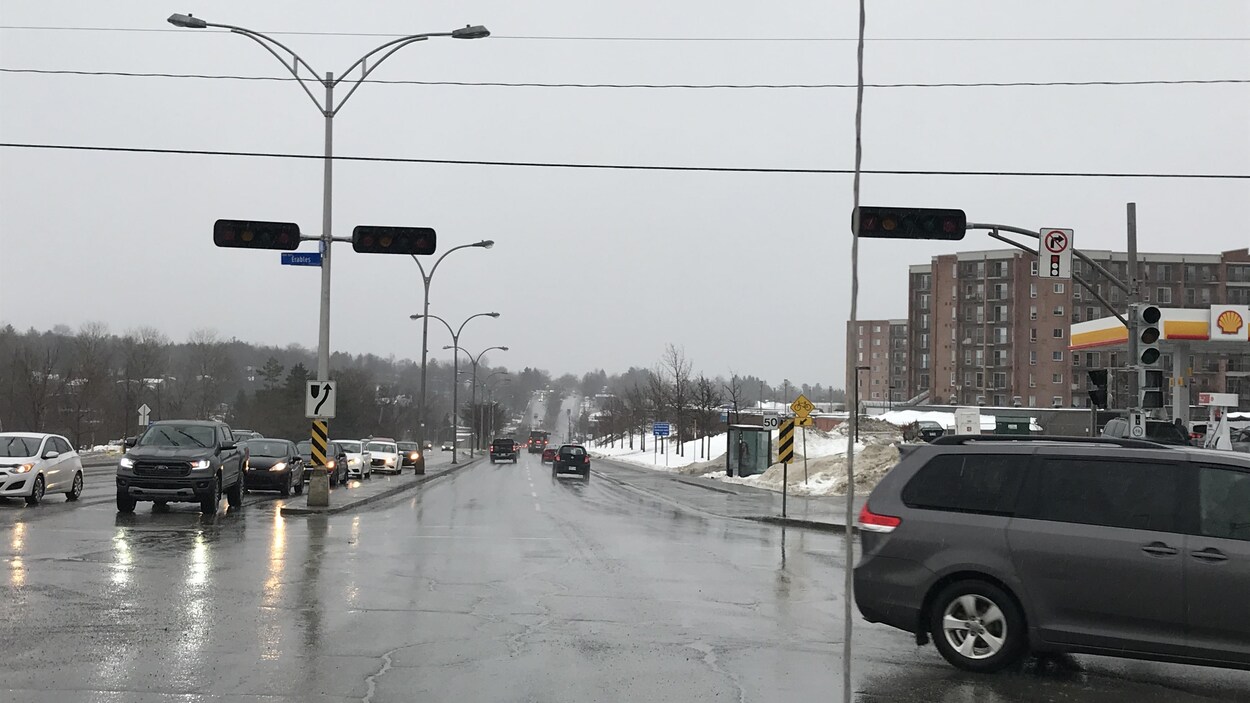 Des voitures à l'arrêt à une intersection dont les feux de signalisation sont éteints.