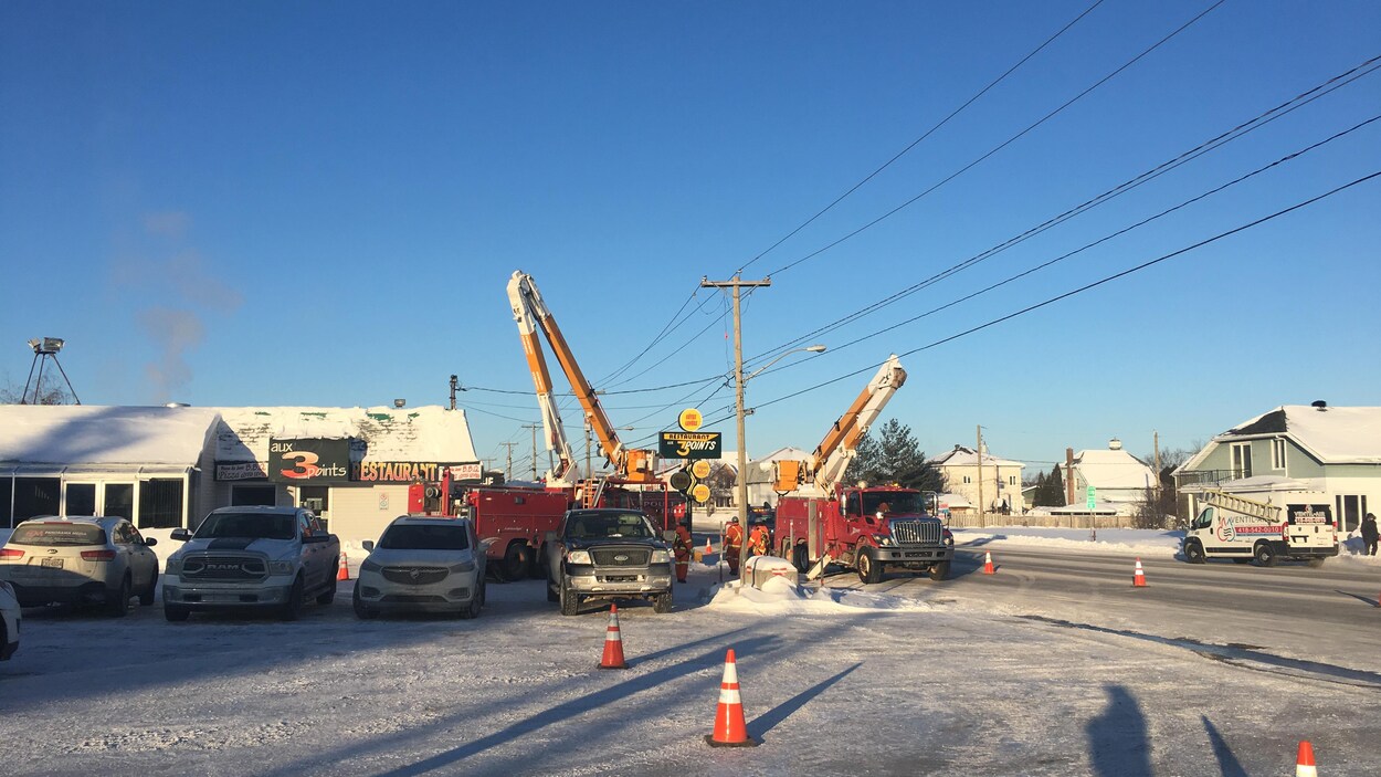 Deux camions d'Hydro Jonquière sont installés près du poteau défectueux.