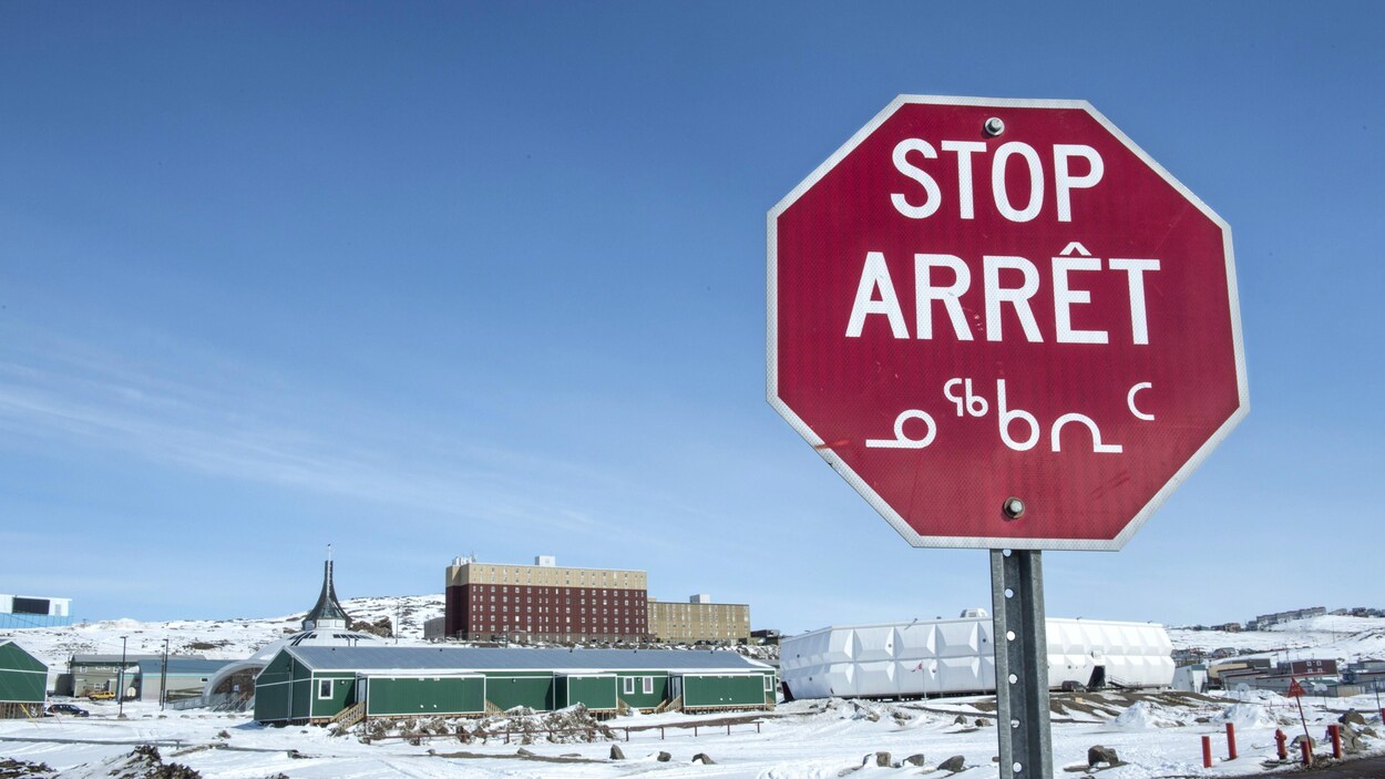 Un panneau d'arrêt en trois langues à Iqaluit.