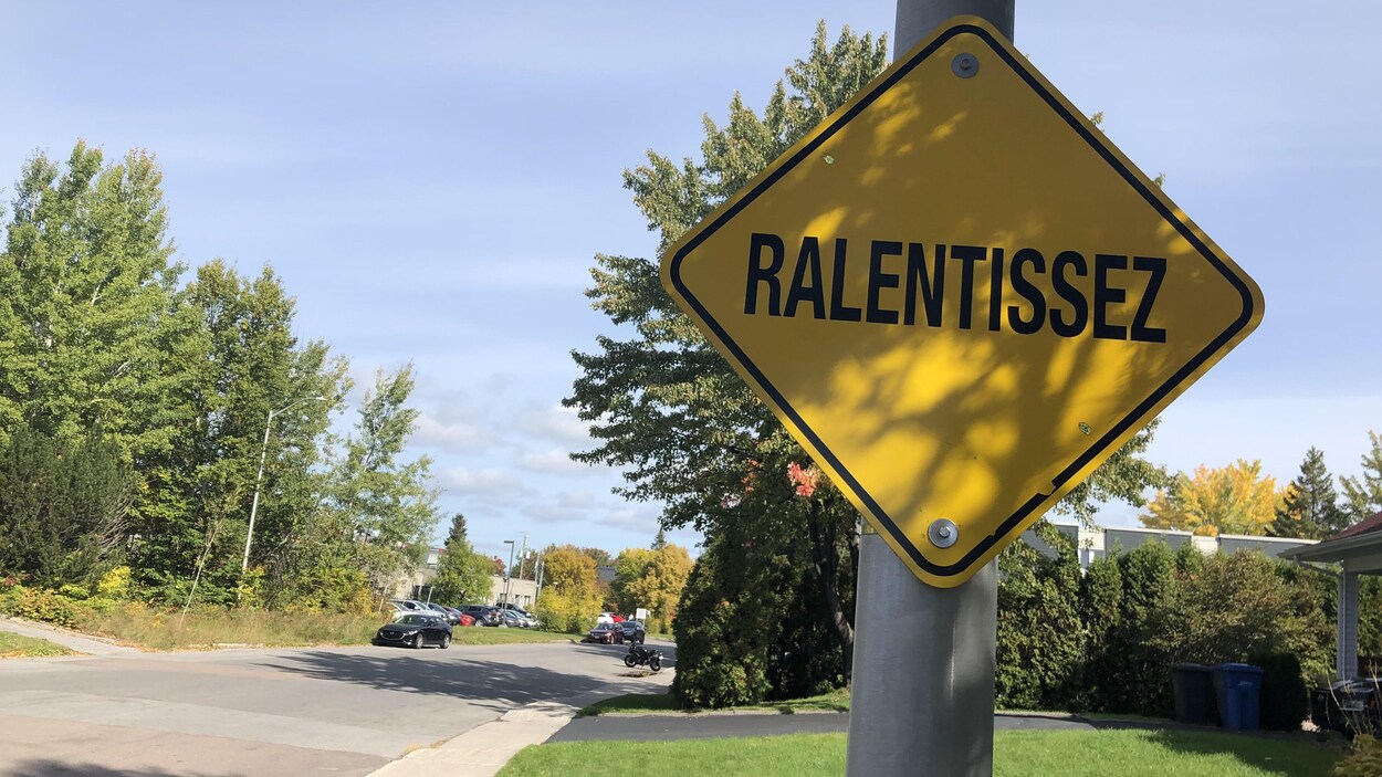 Un panneau de signalisation est placé en bordure de la rue