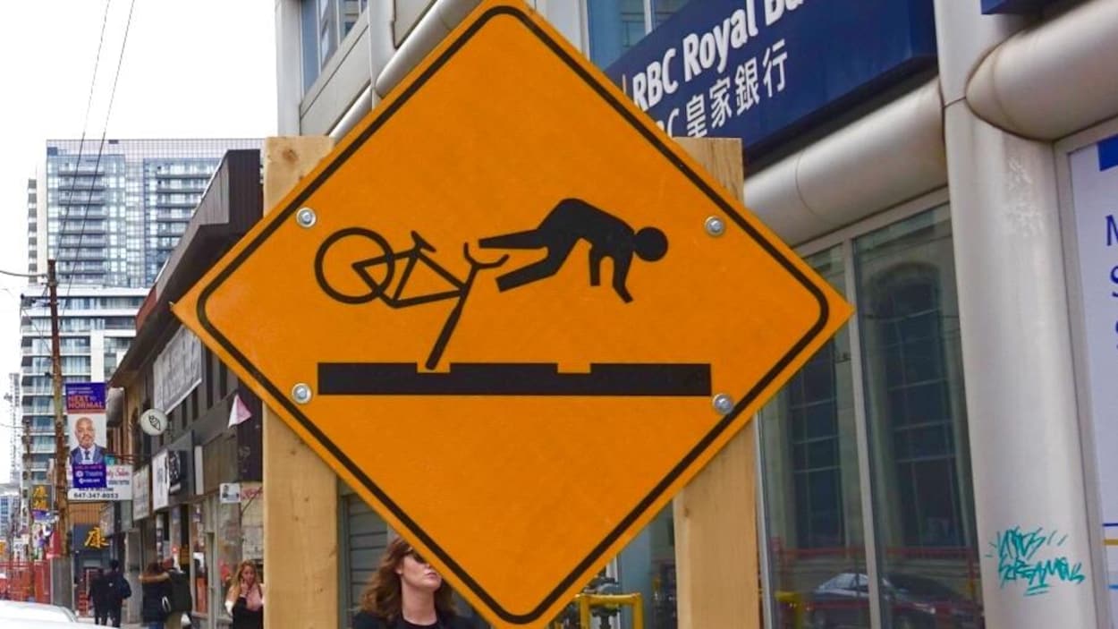 Le panneau de signalisation routière affiche un cycliste en train de chuter au sol en raison d'un trou dans la rue.