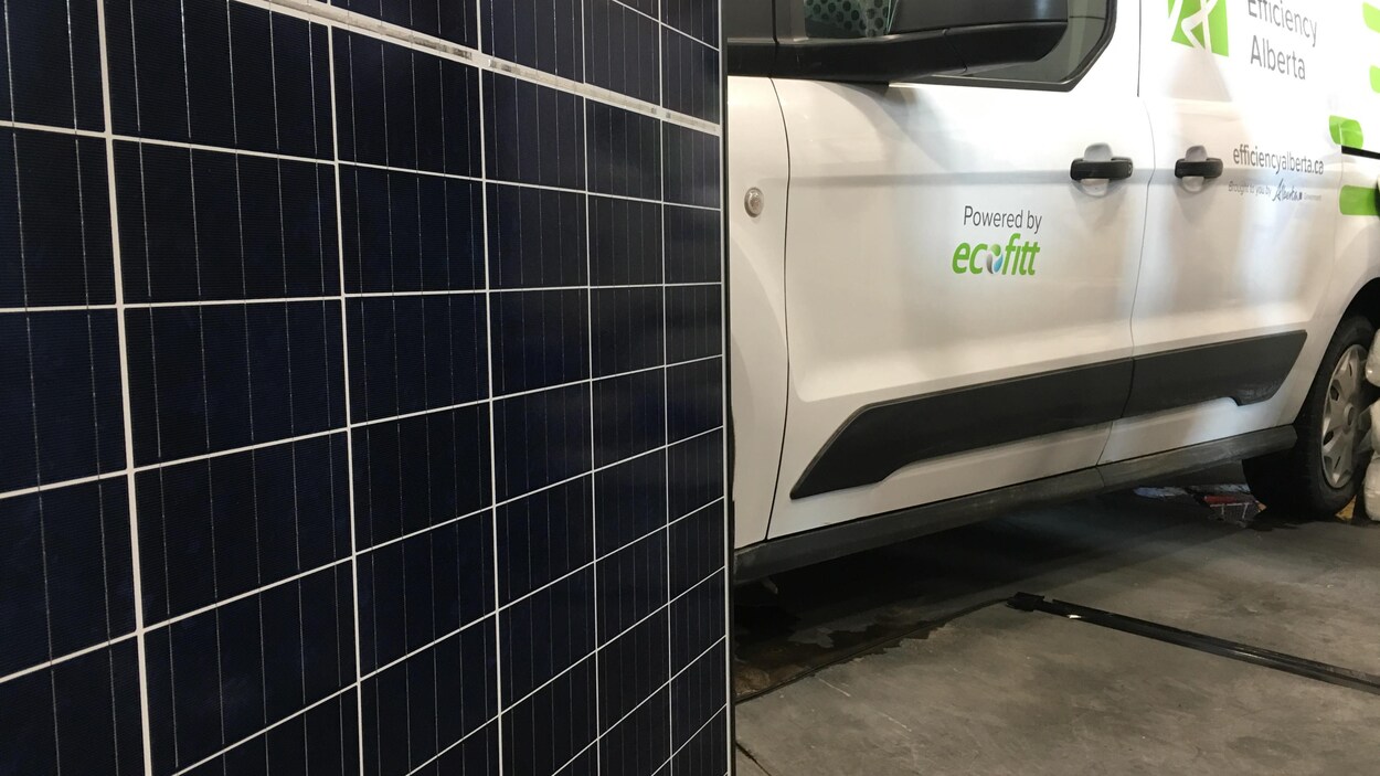 Panneau solaire en premier plan, une voiture blanche derrière. Plus de 500 résidences et commerces ont adhéré au programme d'énergie solaire en Alberta en 2017. Panneau solaire en premier plan, une voiture blanche derrière. Plus de 500 résidences et commerces ont adhéré au programme d'énergie solaire en Alberta en 2017.