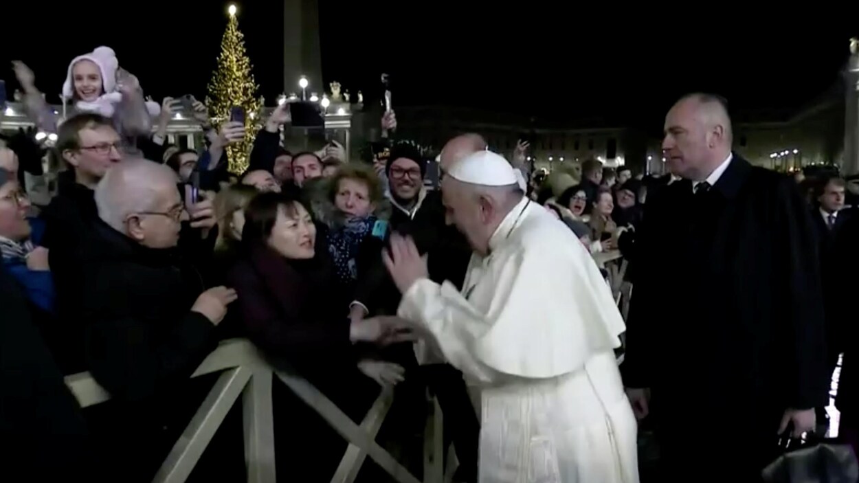 Le pape François tape la main d'une femme qui a saisi son bras à la place Saint-Pierre.