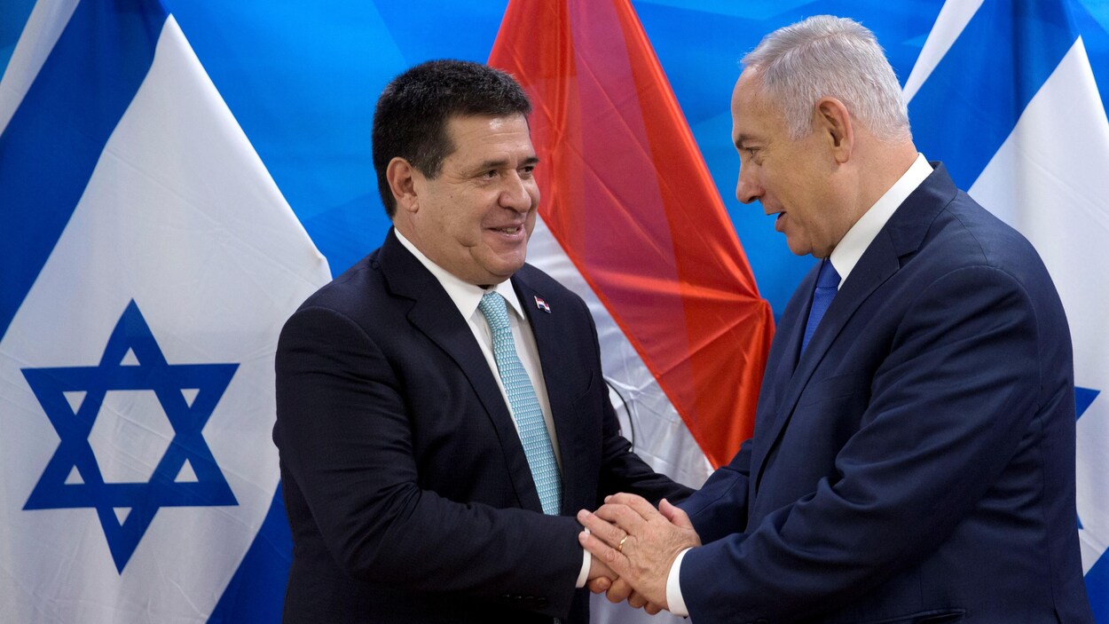 Les deux dirigeants se serrent la main, devant les drapeaux d'Israël et du Paraguay. Les deux dirigeants se serrent la main, devant les drapeaux d'Israël et du Paraguay.