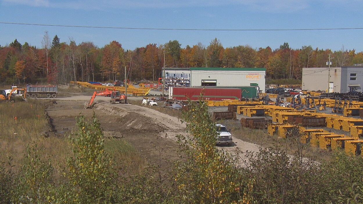 Une pelle mécanique dans le parc industriel d'Asbestos à côté de deux autres usines déjà en activité.