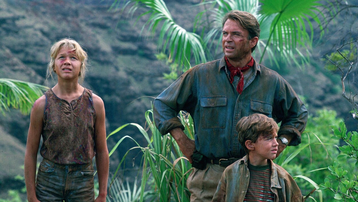 Un homme et deux enfants, une fille et un garçon, sont dans une forêt et portent des habits tachés de terre.