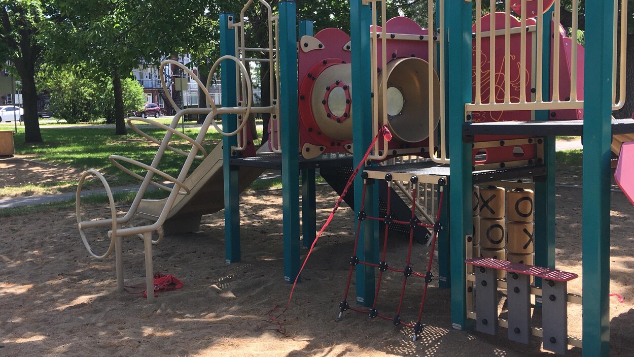 Des modules de jeux pour enfants entourés de sable.