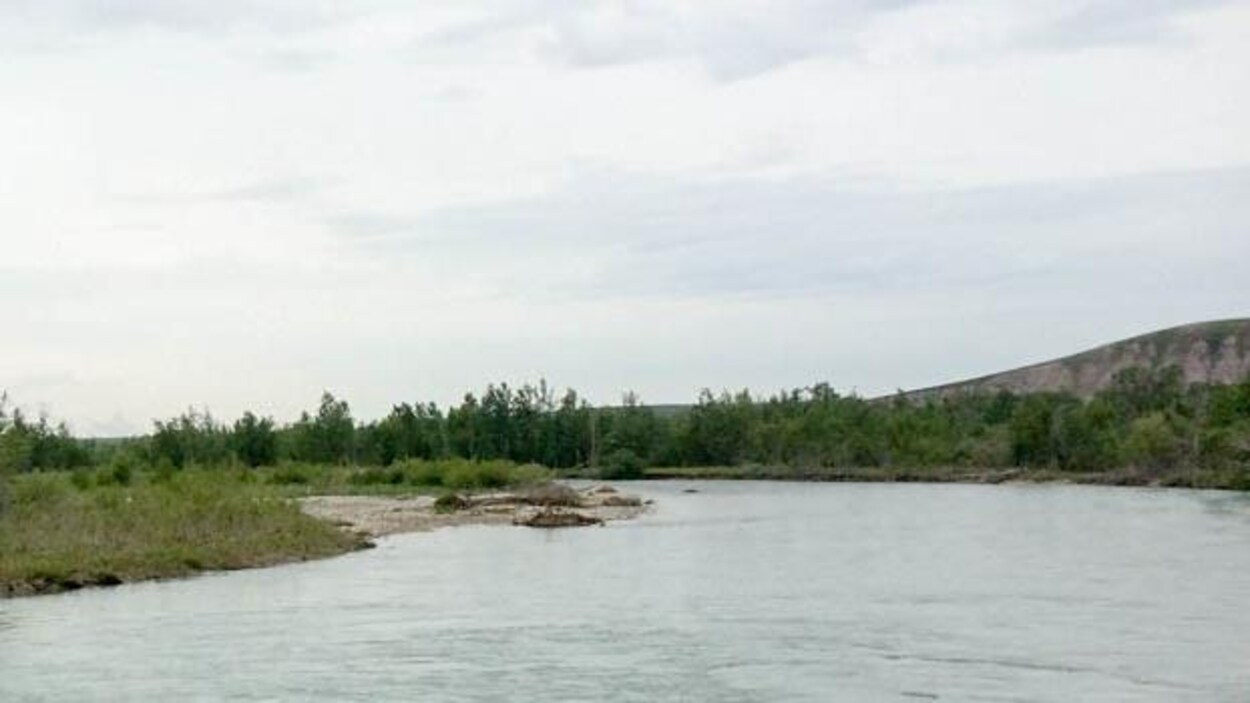 La rivière serpente à travers de petites collines.