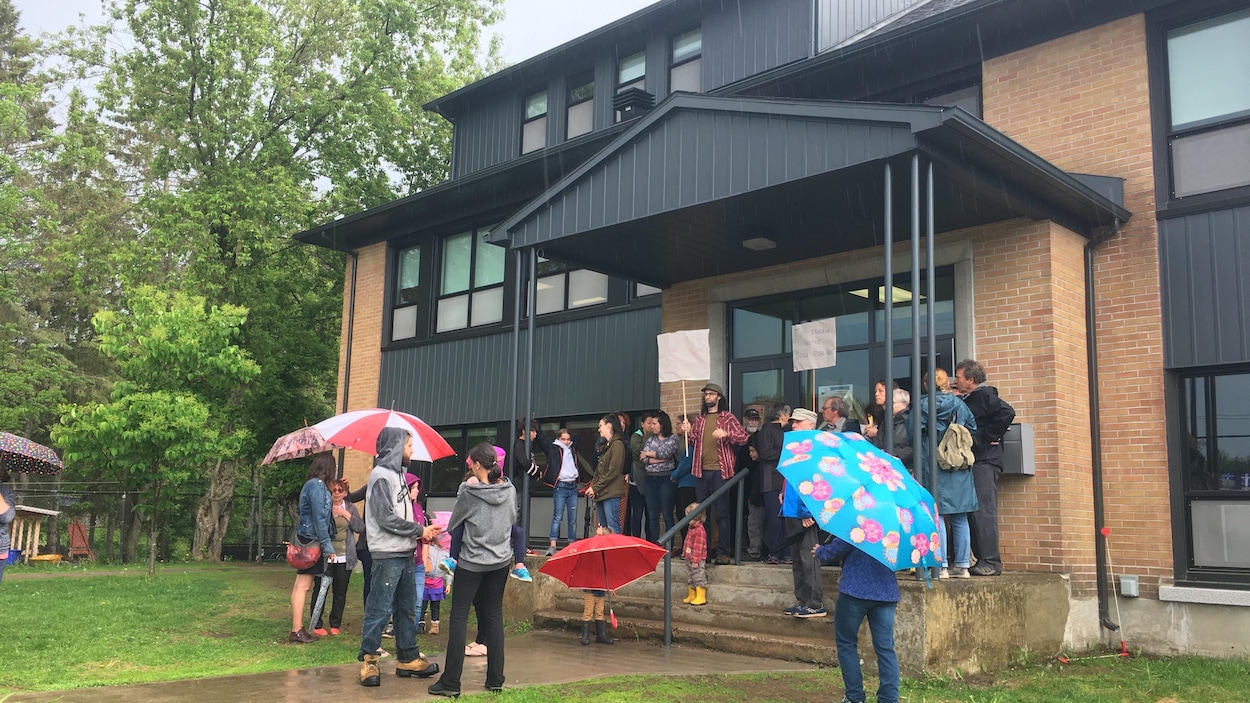 Des gens debout devant une école