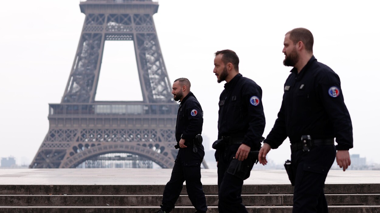 Trois policiers près de la tour Eiffel.
