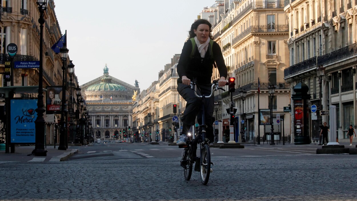 La femme est sur son vélo dans une rue vide.