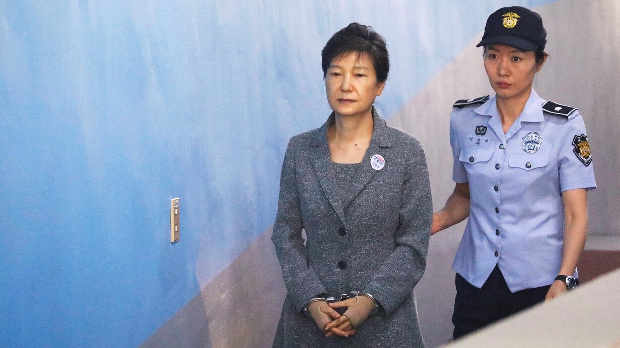 L'ancienne présidente sud-coréenne Park Geun-hye arrive en cour escortée par une policière, à Séoul, le 25 août 2017. L'ancienne présidente sud-coréenne Park Geun-hye arrive en cour escortée par une policière, à Séoul, le 25 août 2017.