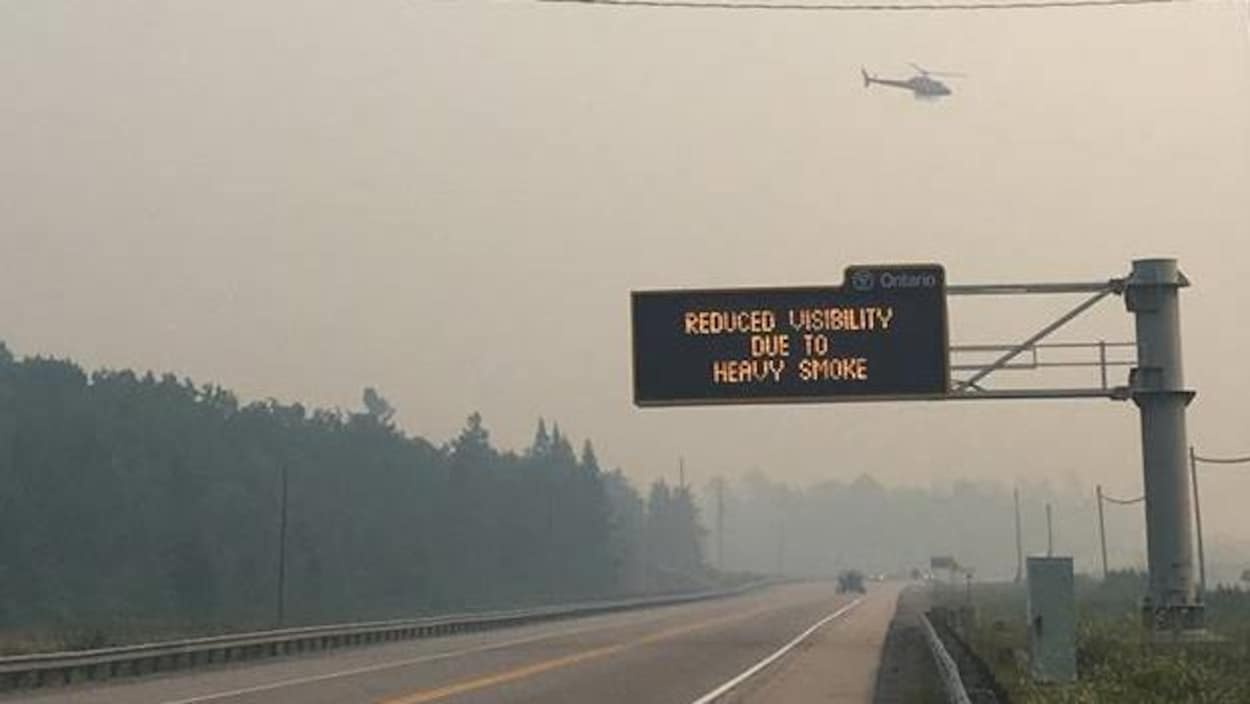 Un signal routier indiquant une visibilité réduite en raison de la fumée Un signal routier indiquant une visibilité réduite en raison de la fumée