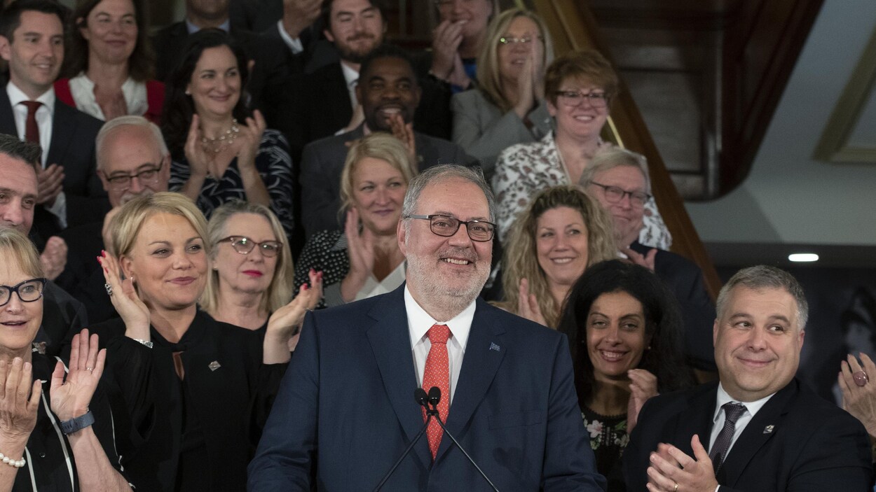 Les députés du Parti libéral du Québec entourent leur chef et applaudissent.