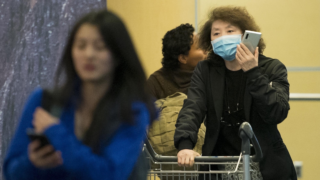Une passagère porte un masque à son arrivée à l'aéroport de Vancouver.