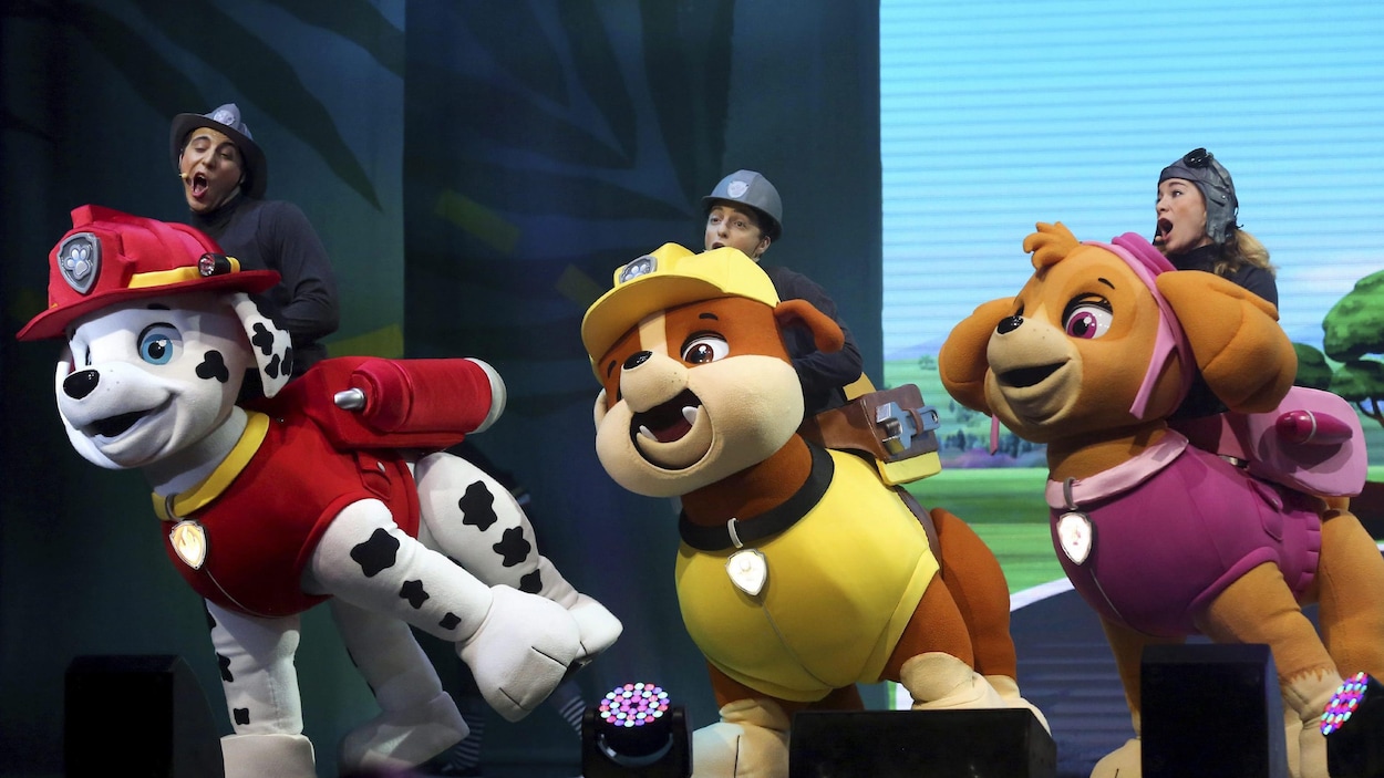 Des comédiens contrôlent des marionnettes géantes à l'effigie des petits chiens de la série. Des comédiens contrôlent des marionnettes géantes à l'effigie des petits chiens de la série.