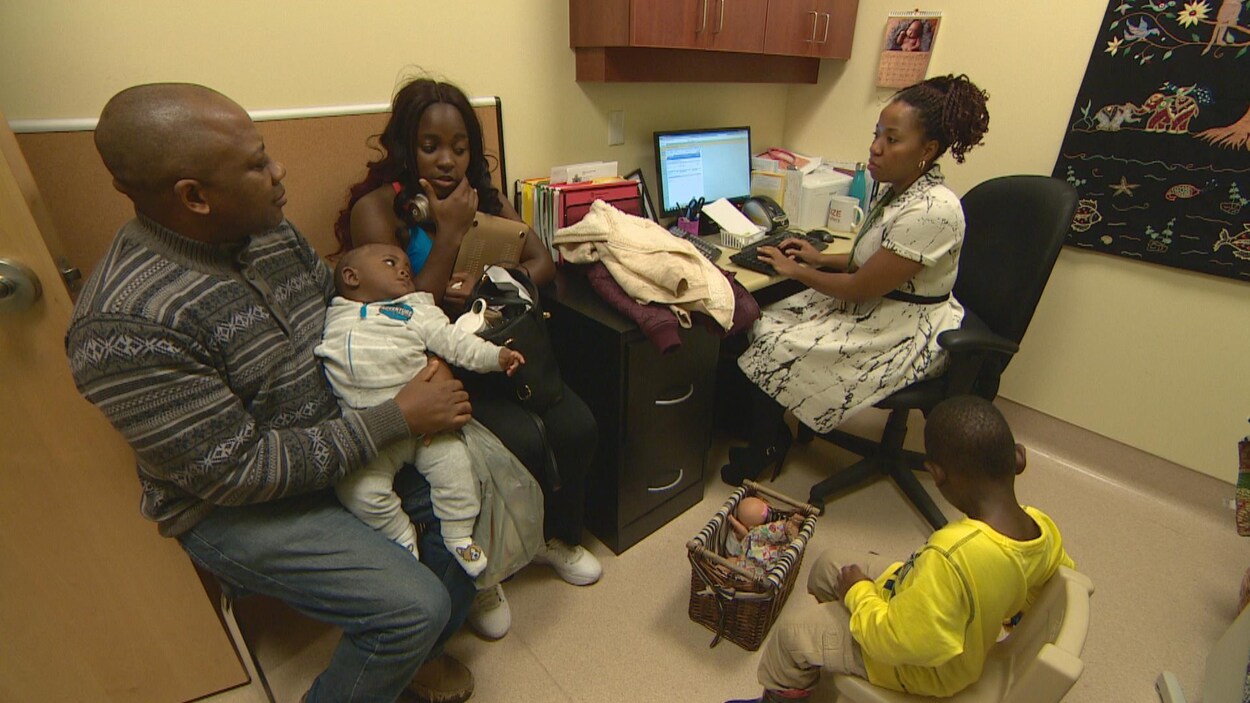 Un père une mere un bébé un bambin dans le bureau d'une infirmière Un père une mere un bébé un bambin dans le bureau d'une infirmière