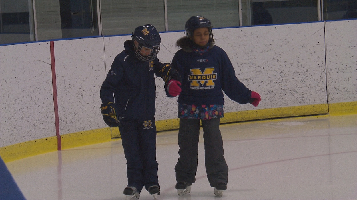 Deux enfants patinent ensemble.