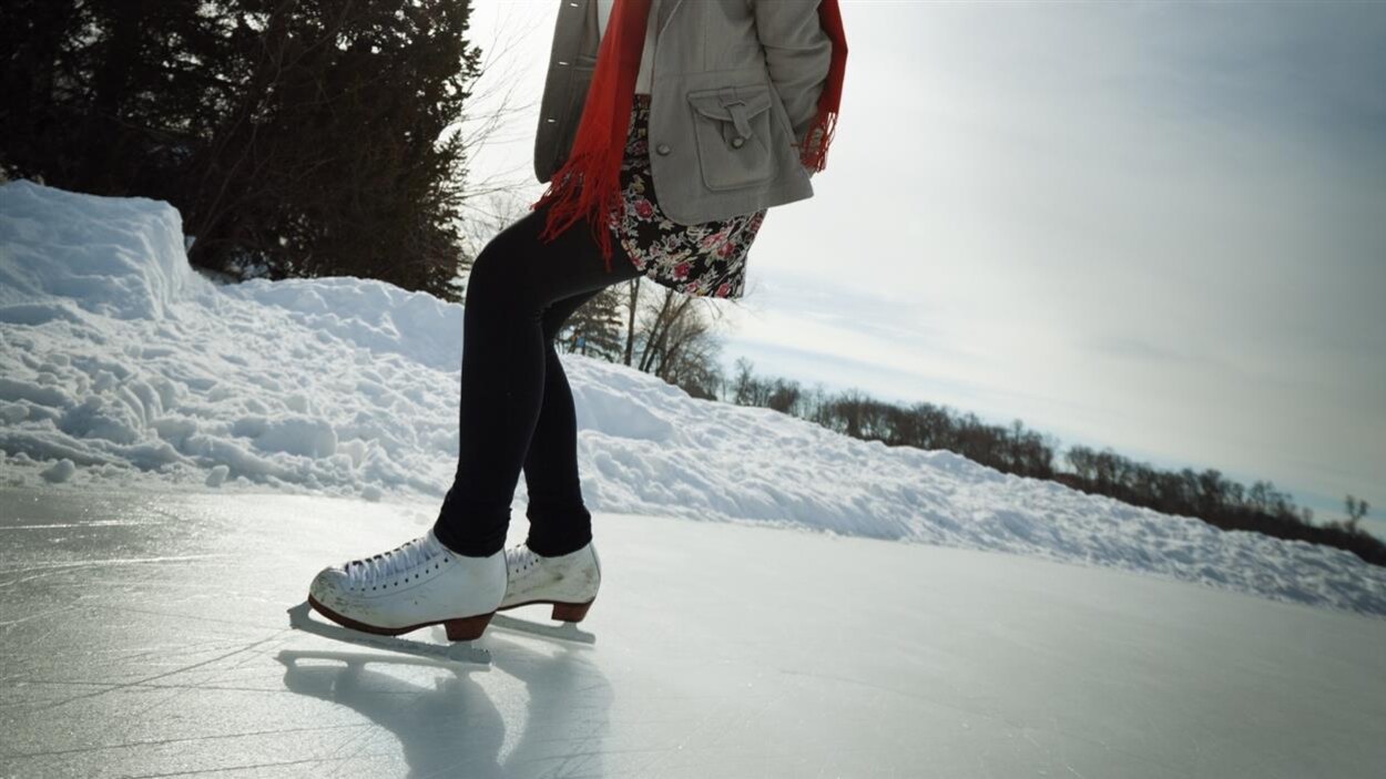 Une patineuse s’exerce sur un anneau de glace.