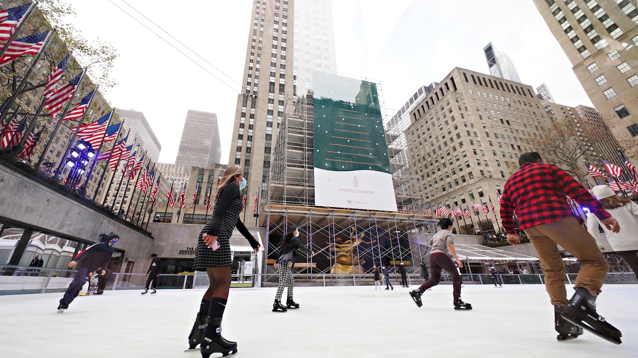 Des gens masqués patinent à distance au Rockefeller Center, le 21 novembre 2020.