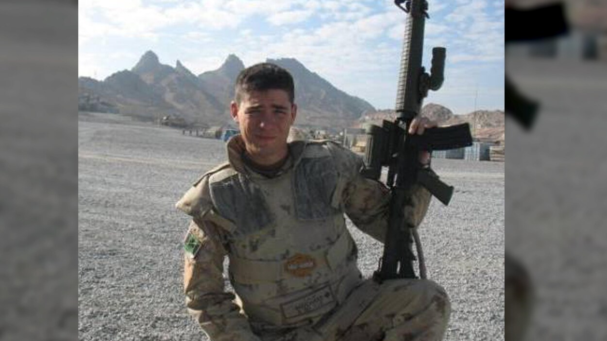 Homme avec un fusil dans un endroit désertique.