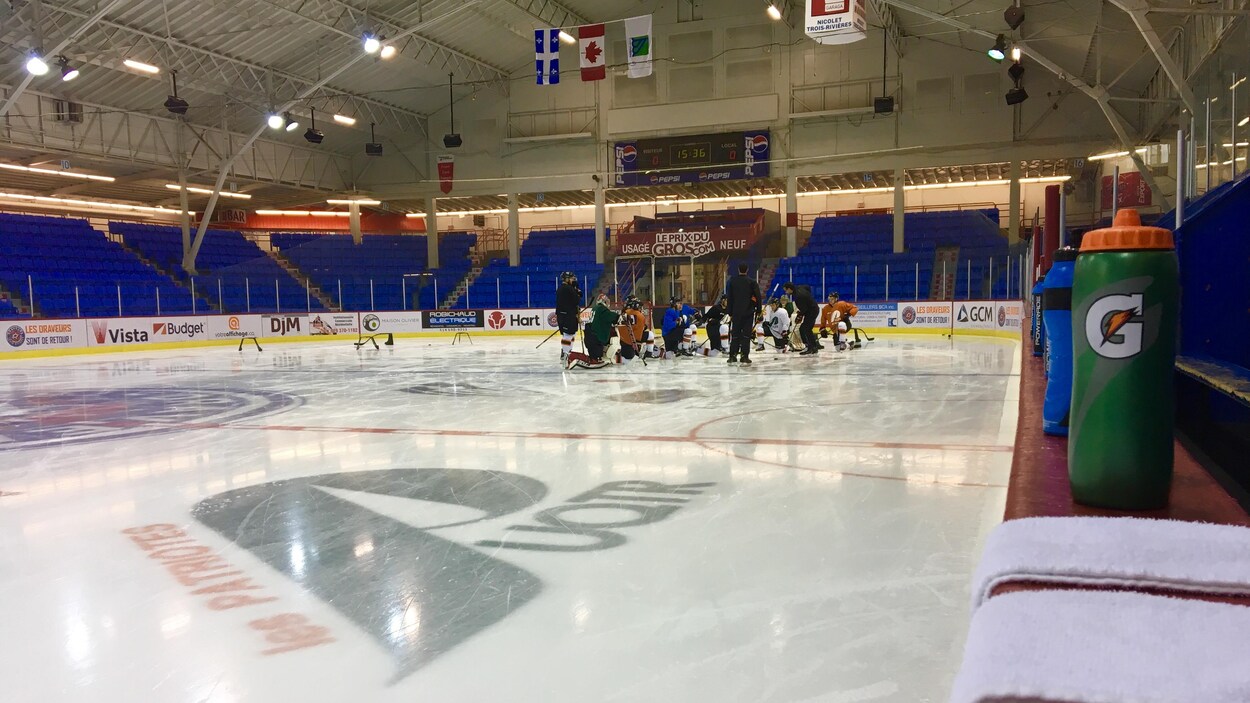 Les joueurs et leurs entraîneurs lors d'une pratique à l'aréna