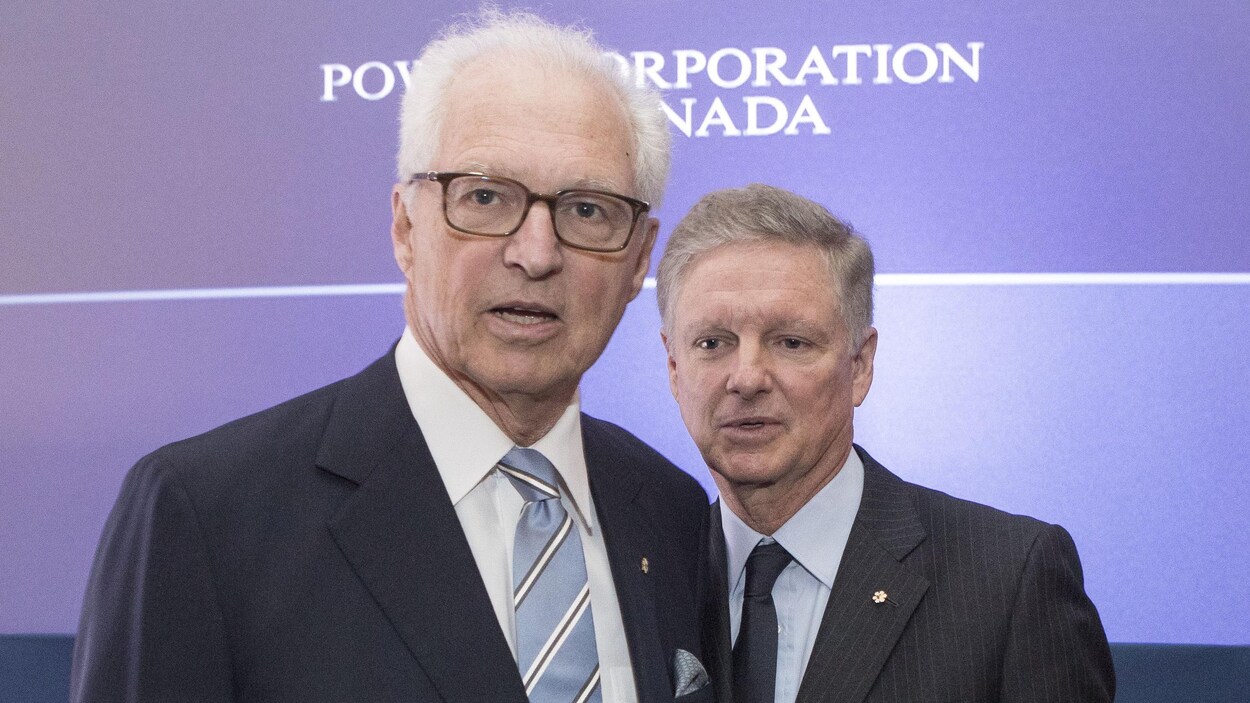 Plan moyen des deux hommes devant le logo de Power.