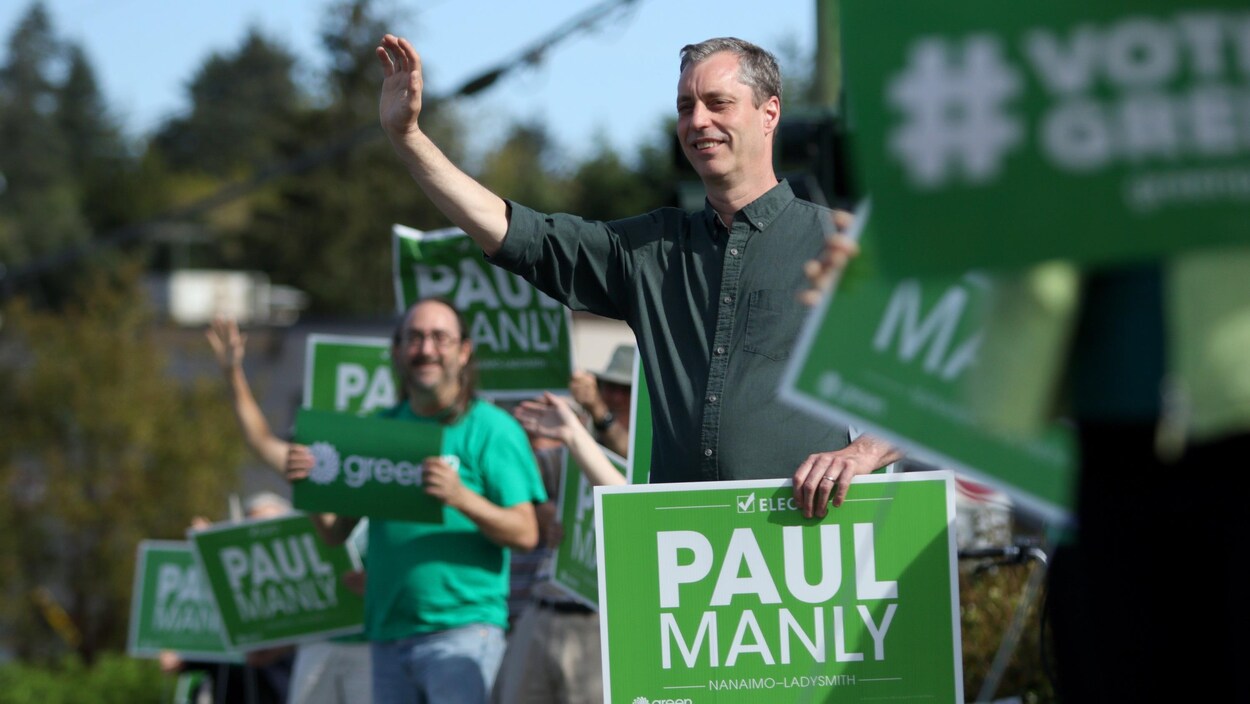 Paul Manly salue ses partisans lors d'un événement.
