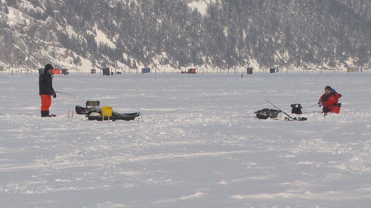 Des pêcheurs sont installés sur la glace avant l'embarquement des cabanes.