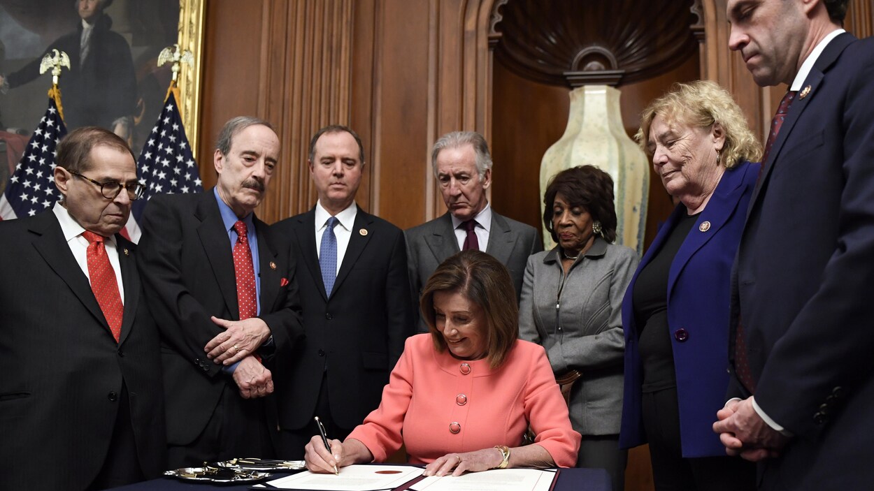 Souriante, Nancy Pelosi signe l'acte d'accusation, entourée des responsables de la mise en accusation et des présidents des comités de la Chambre ayant mené l'enquête en destitution.