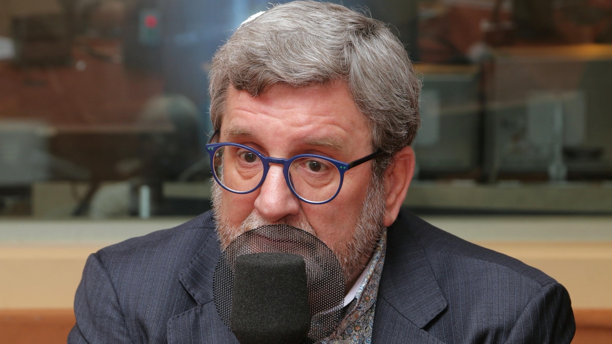 Photo de Régis Labeaume devant un micro de radio.
