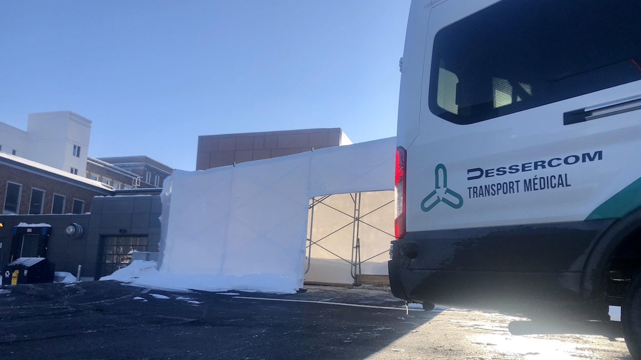 Le derrière d'un camion de transport médical adapté dans un stationnement.