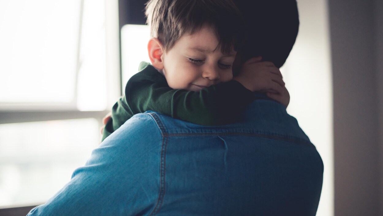 Un père prend son fils dans ses bras Un père prend son fils dans ses bras