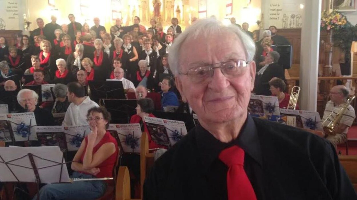 Le père Maurice LeBlanc est devant une chorale. 