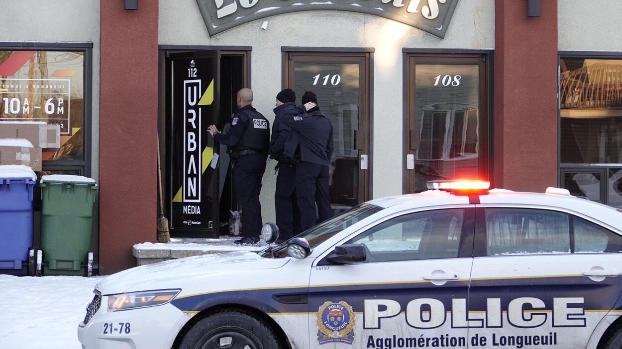 Trois policiers entrent dans un commerce.