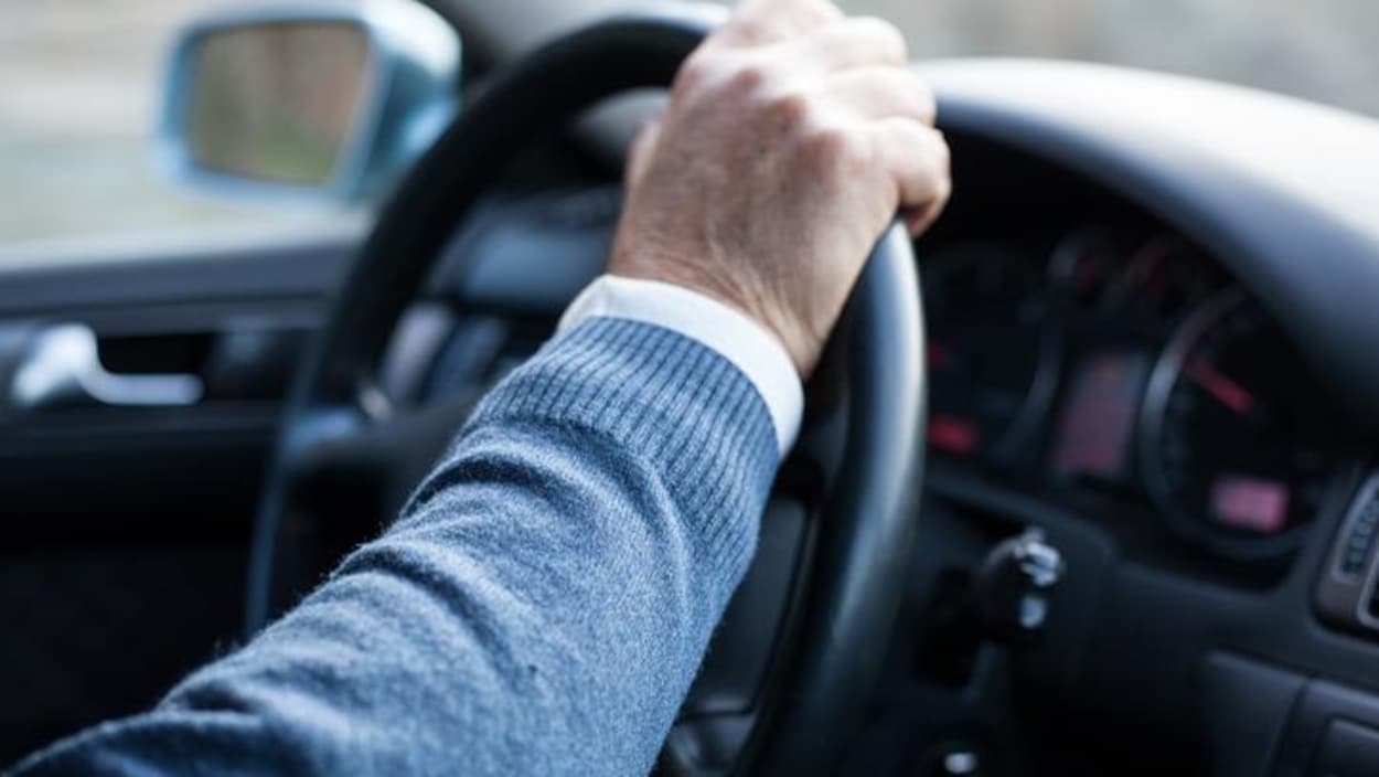 Une personne aînée qui conduit.