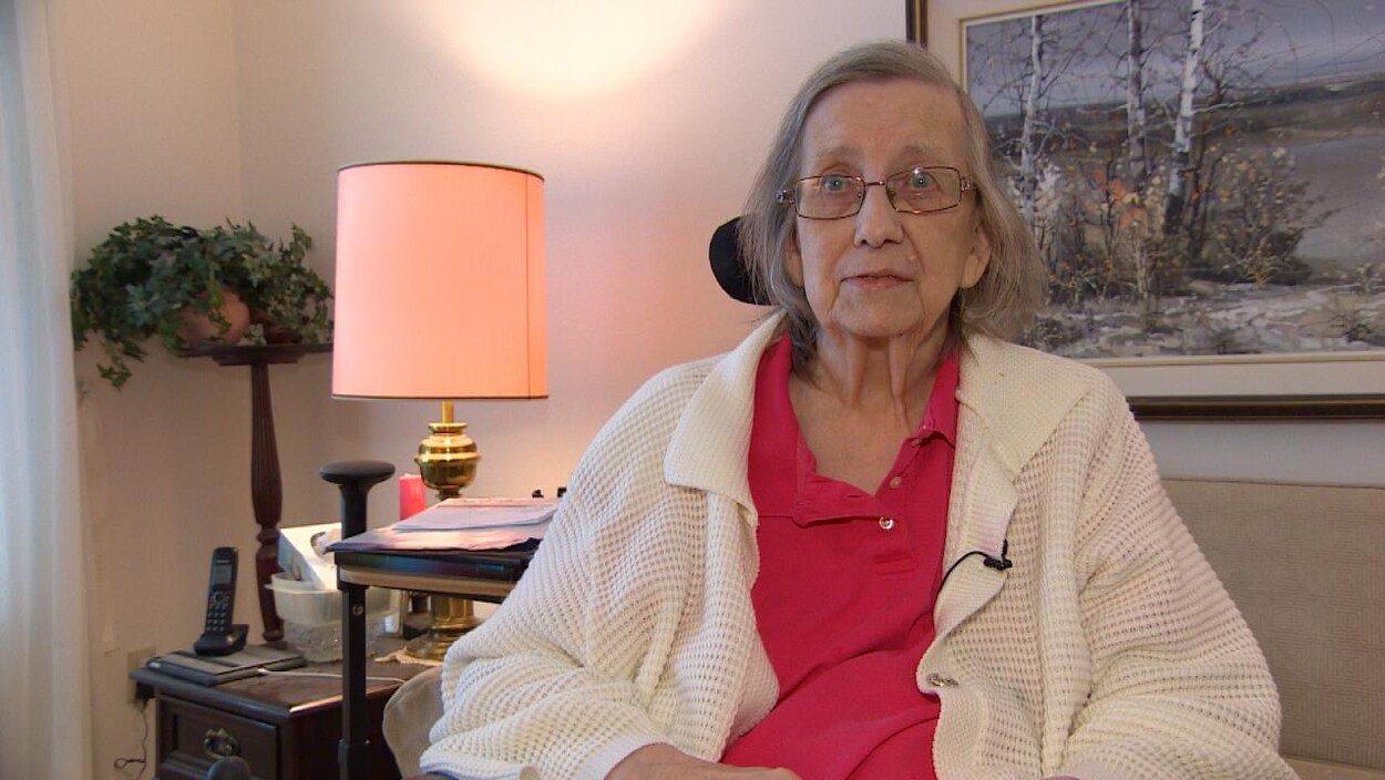 Plan moyen d'Alice Balork assise dans un salon.